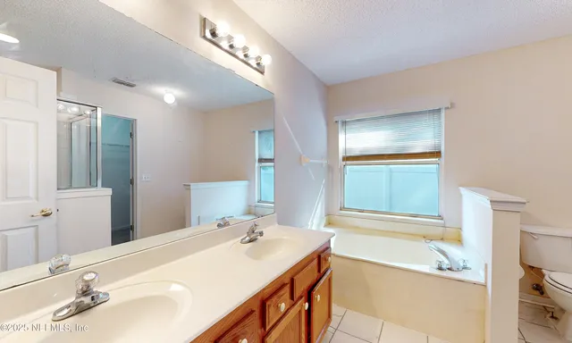 a bathroom with a tub sink and mirror