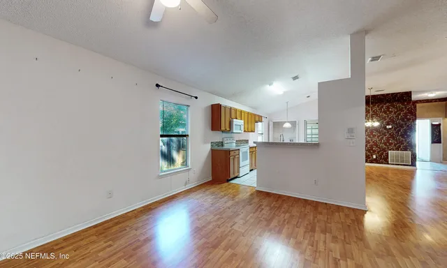 a view of a kitchen with wooden floor and a kitchen