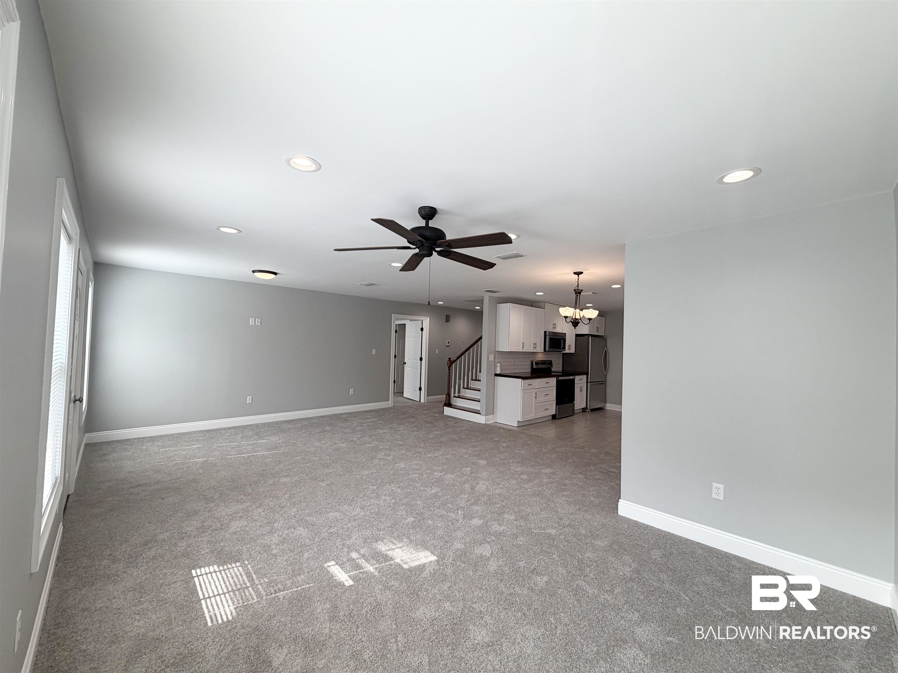 2454 Taylor Avenue Mobile, AL 36606 - Photo 23 of 24 Unfurnished living room featuring light colored carpet, a ceiling fan, and suspended lighting