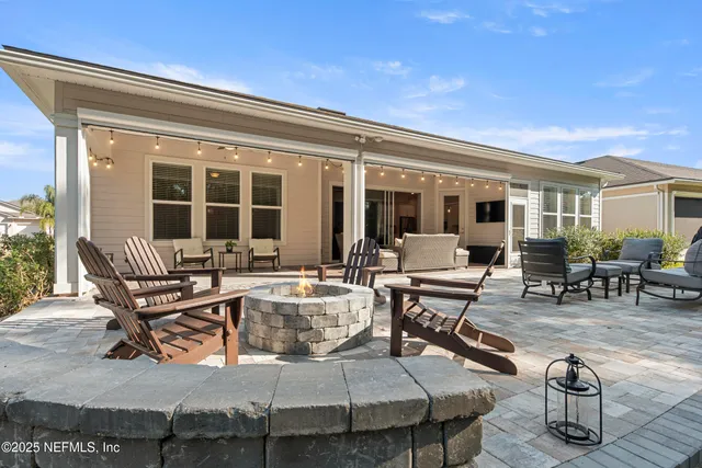 a view of a patio with table and chairs and wooden fence