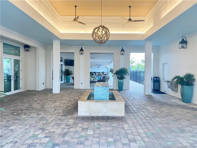 a view of a hallway with dining space and chandelier