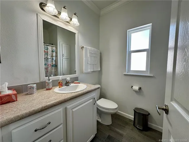 a bathroom with a granite countertop toilet sink and mirror