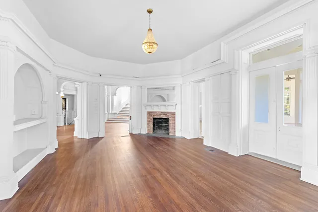 a view of a livingroom with wooden floor and a fireplace