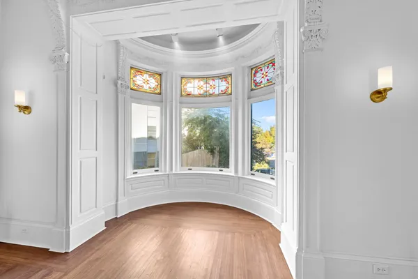 an entryway to room with wooden floor and windows