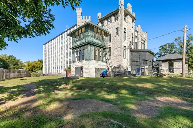 a view of a big house with a big yard and large trees