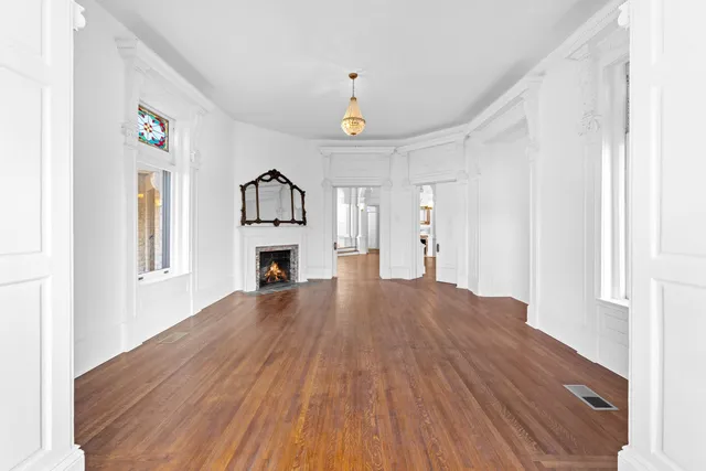 a view of empty room with wooden floor and fireplace