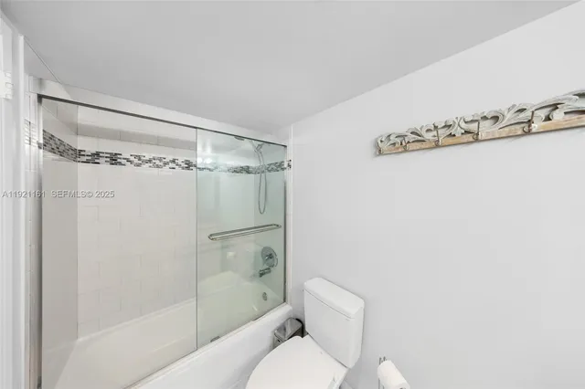 a bathroom with a granite countertop toilet sink and mirror