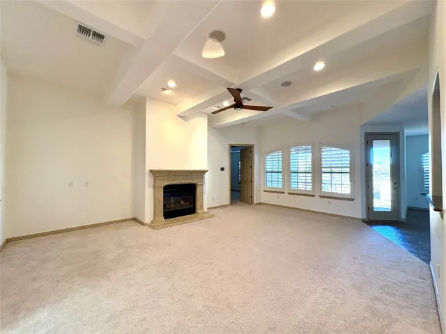 a view of an empty room with a fireplace and a window