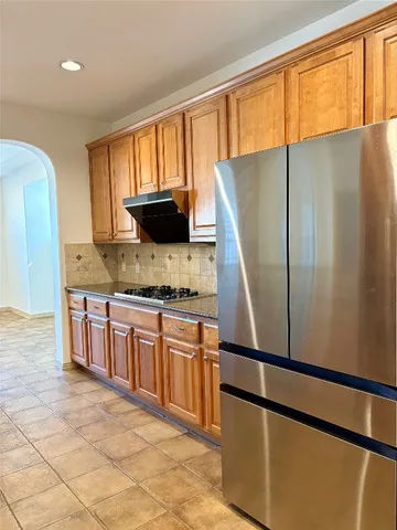 a kitchen with stainless steel appliances granite countertop a refrigerator a stove a sink dishwasher and a refrigerator