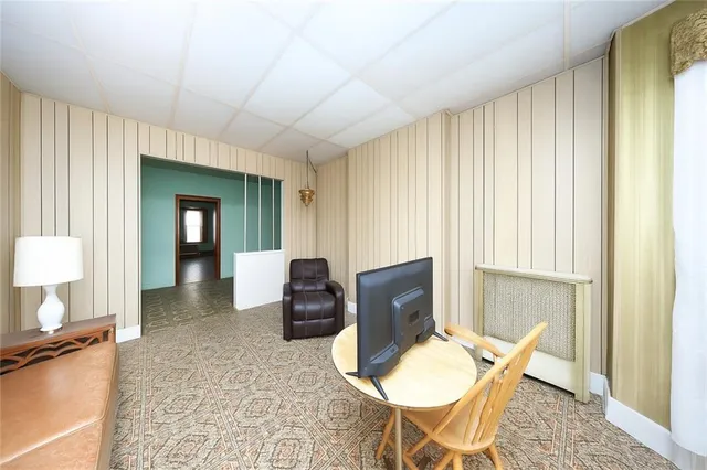 a living room with furniture a flat screen tv and a window