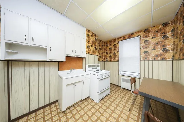 a kitchen with a stove a refrigerator and a stove top oven