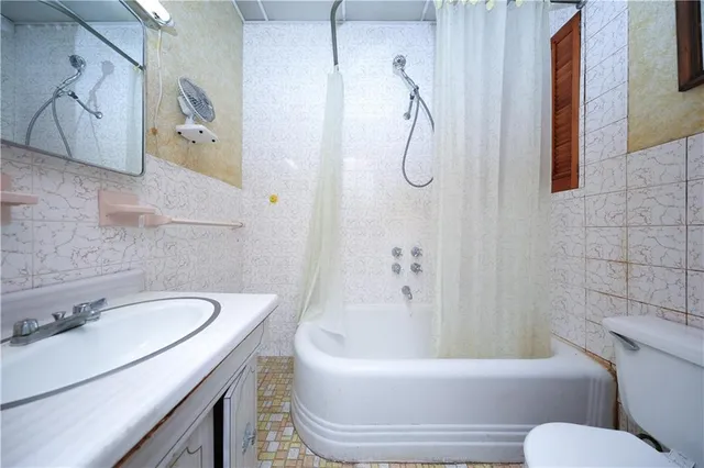 a bathroom with a granite countertop sink a toilet and bathtub