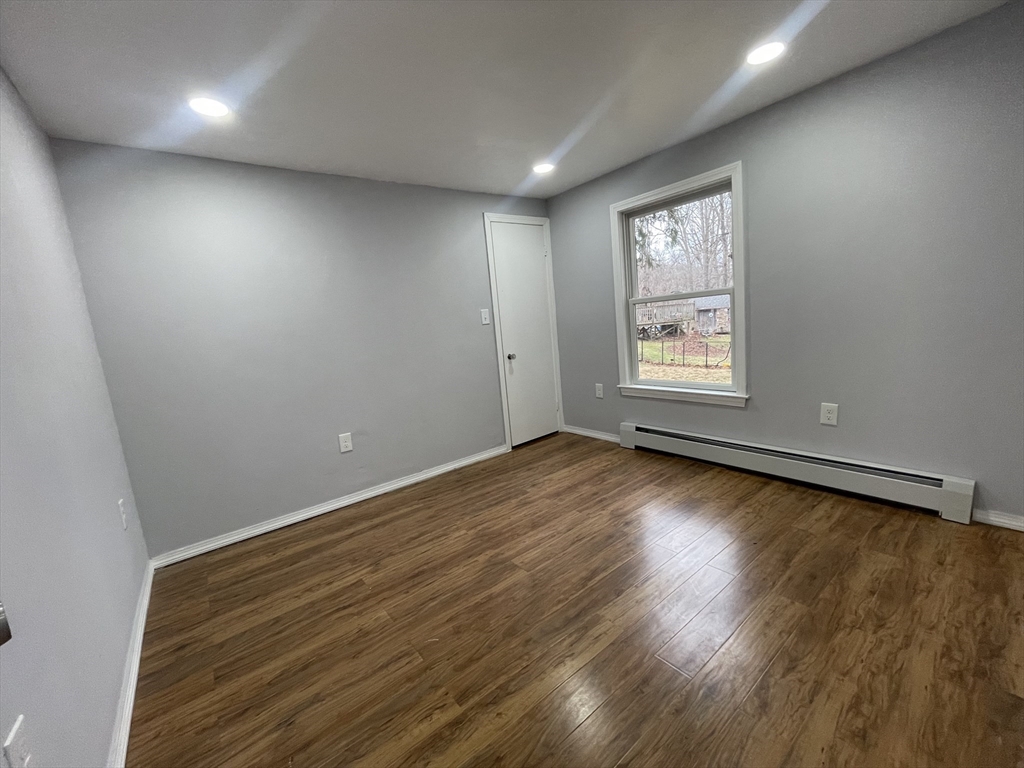 59 High Street Warren, MA 01083 - Photo 14 of 42 an empty room with wooden floor and windows