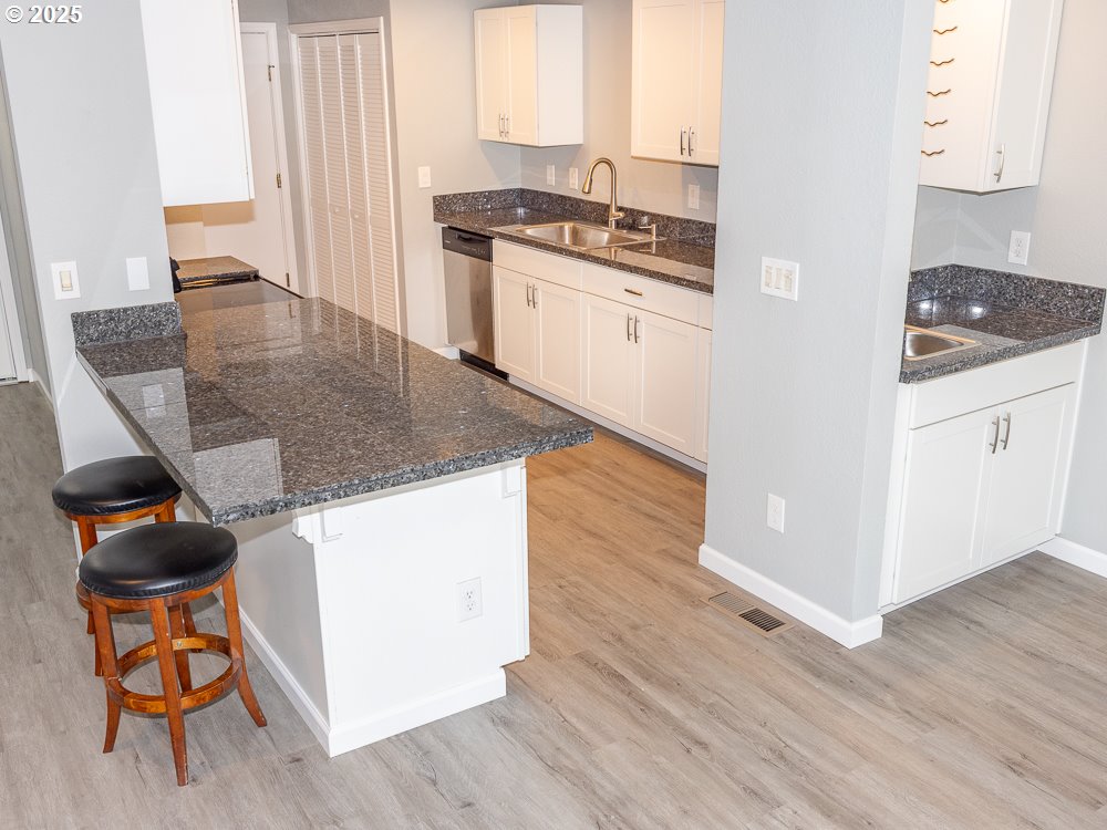 3318 Northeast 29th Street Gresham, OR 97030 - Photo 11 of 32 a kitchen with granite countertop a stove and a wooden floor