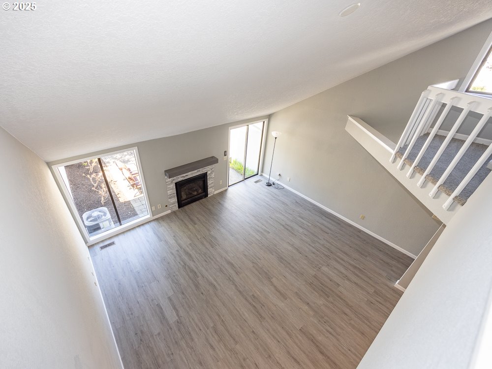 3318 Northeast 29th Street Gresham, OR 97030 - Photo 14 of 32 an empty room with windows fireplace and wooden floor