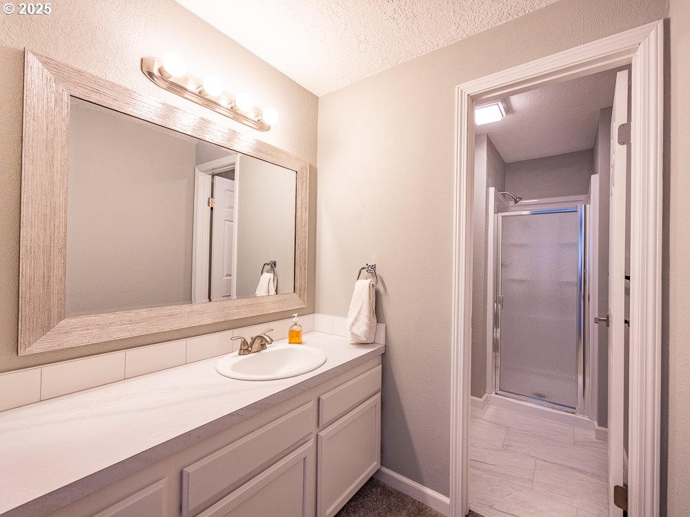 3318 Northeast 29th Street Gresham, OR 97030 - Photo 22 of 32 a bathroom with a sink a mirror and a shower
