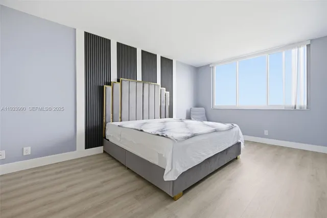 a bed sitting in a spacious bedroom next to a window