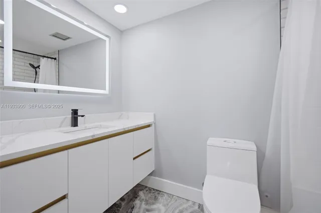 a bathroom with a toilet a sink and mirror