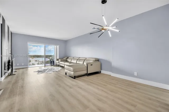a living room with furniture and a large window with wooden floor
