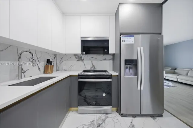 a kitchen with stainless steel appliances granite countertop a refrigerator and a sink