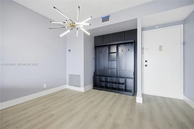 an empty room with a ceiling fan and wooden floor