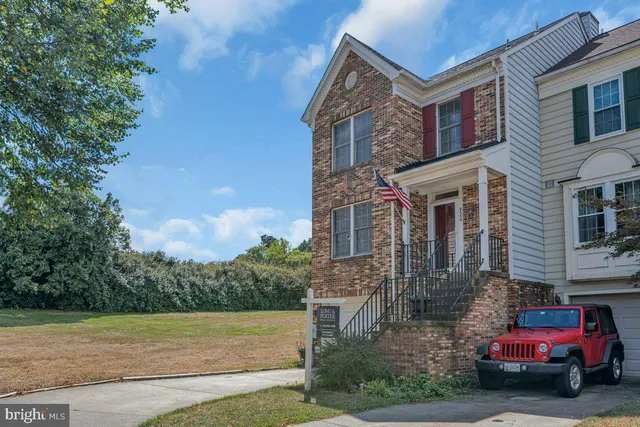 a front view of a house with a garden and trees