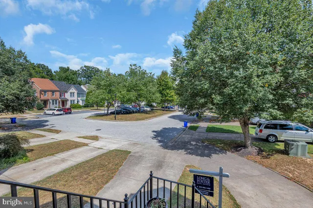 a view of a house with a yard and large tree