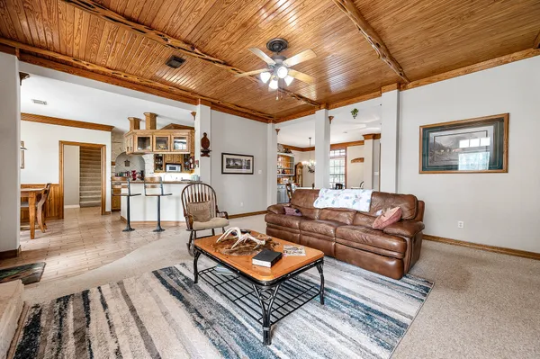 a living room with furniture a rug and wall paintings