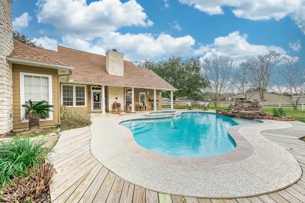 a swimming pool with outdoor seating and yard