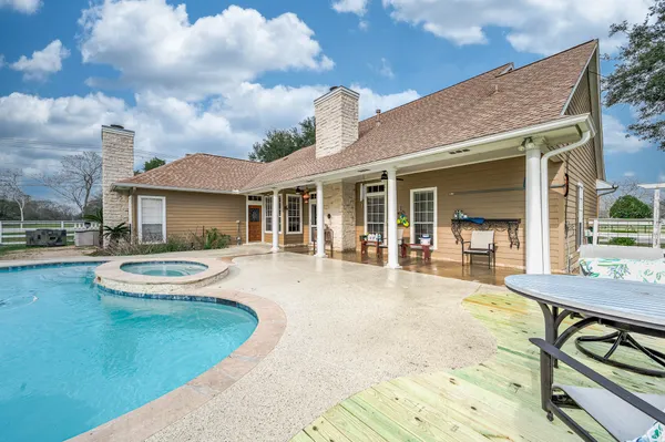 a view of a house with swimming pool and sitting area