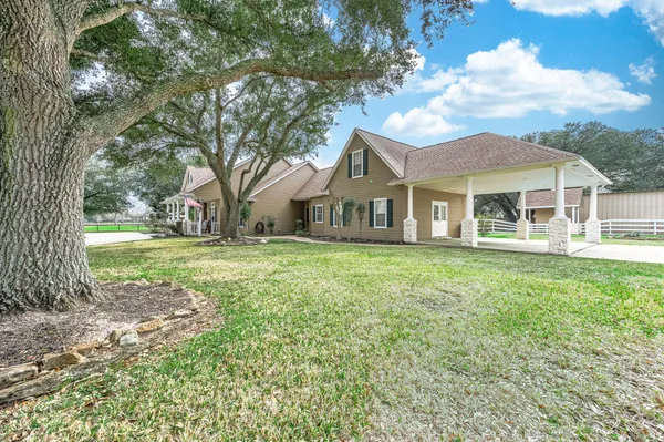 a front view of a house with a garden and trees