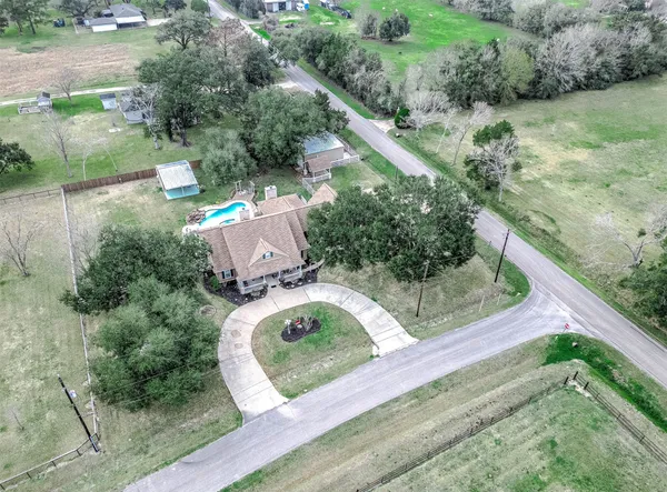 an aerial view of a house with a yard basket ball court and outdoor seating