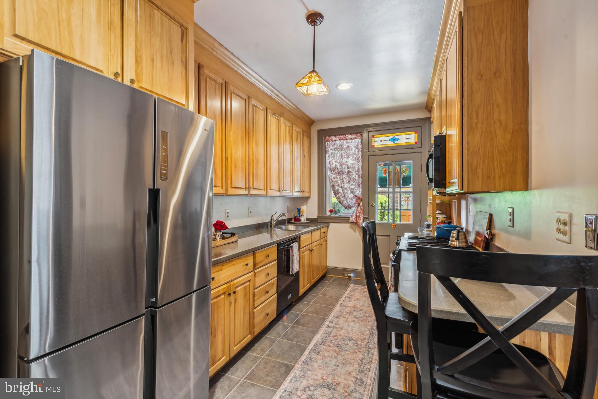 401 Hopkins Road Baltimore, MD 21212 - Photo 18 of 63 a kitchen with stainless steel appliances granite countertop a refrigerator a sink dishwasher a stove and a dining table with wooden cabinet