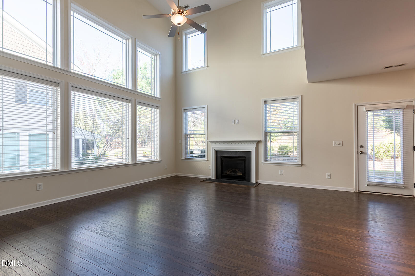 209 Mayfield Drive Apex, NC 27539 - Photo 12 of 48 an empty room with wooden floor fireplace and windows