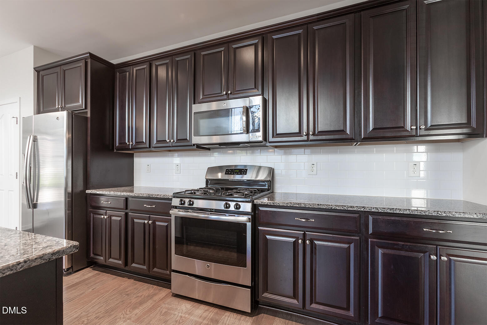 209 Mayfield Drive Apex, NC 27539 - Photo 15 of 48 a kitchen with granite countertop wooden cabinets and stainless steel appliances