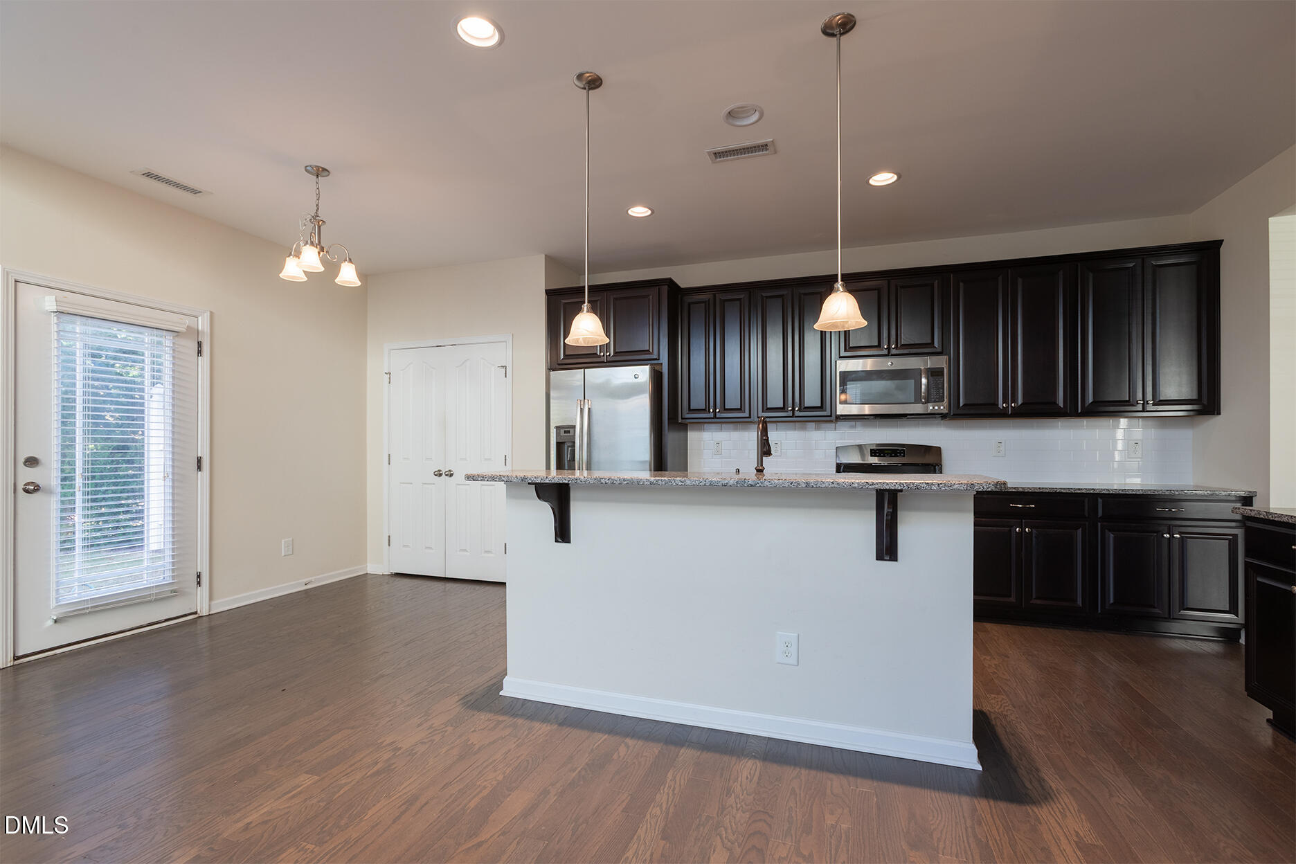 209 Mayfield Drive Apex, NC 27539 - Photo 17 of 48 an open kitchen with wooden floor and stainless steel appliances