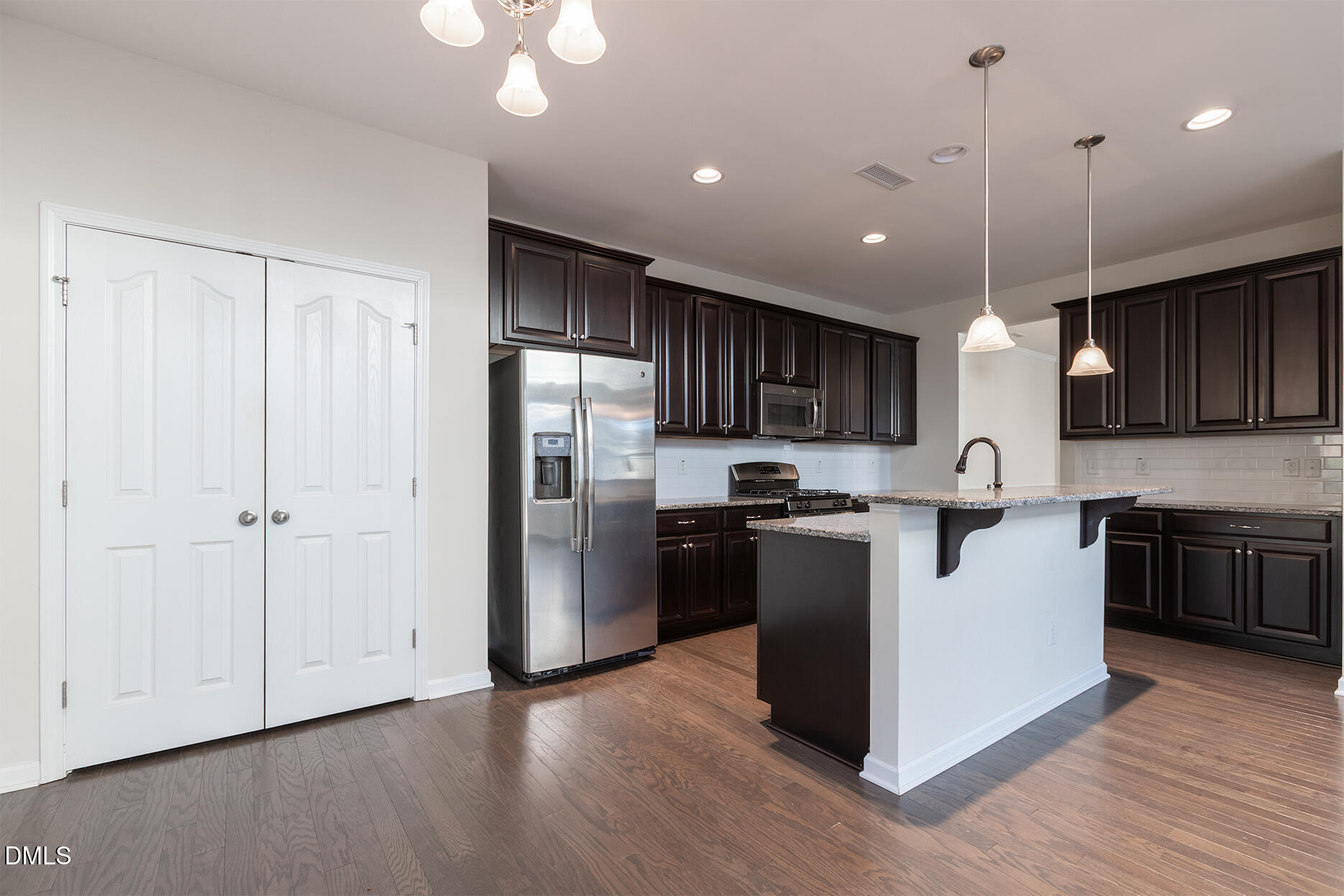 209 Mayfield Drive Apex, NC 27539 - Photo 18 of 48 a kitchen with stainless steel appliances granite countertop a refrigerator a sink dishwasher a kitchen island a stove and a wooden floors