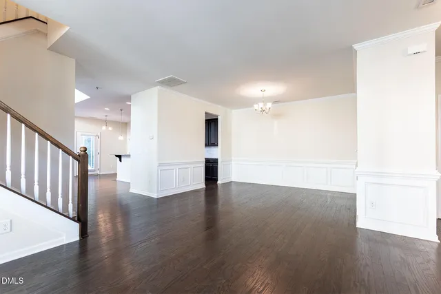 an open kitchen with wooden floor and stainless steel appliances