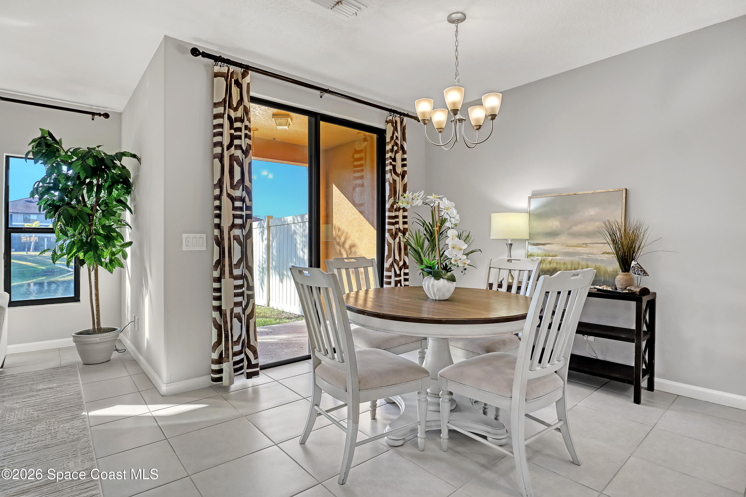 1420 Lara Circle, Unit 102 Rockledge, FL 32955 - Photo 12 of 38 a view of a dining room with furniture and a chandelier
