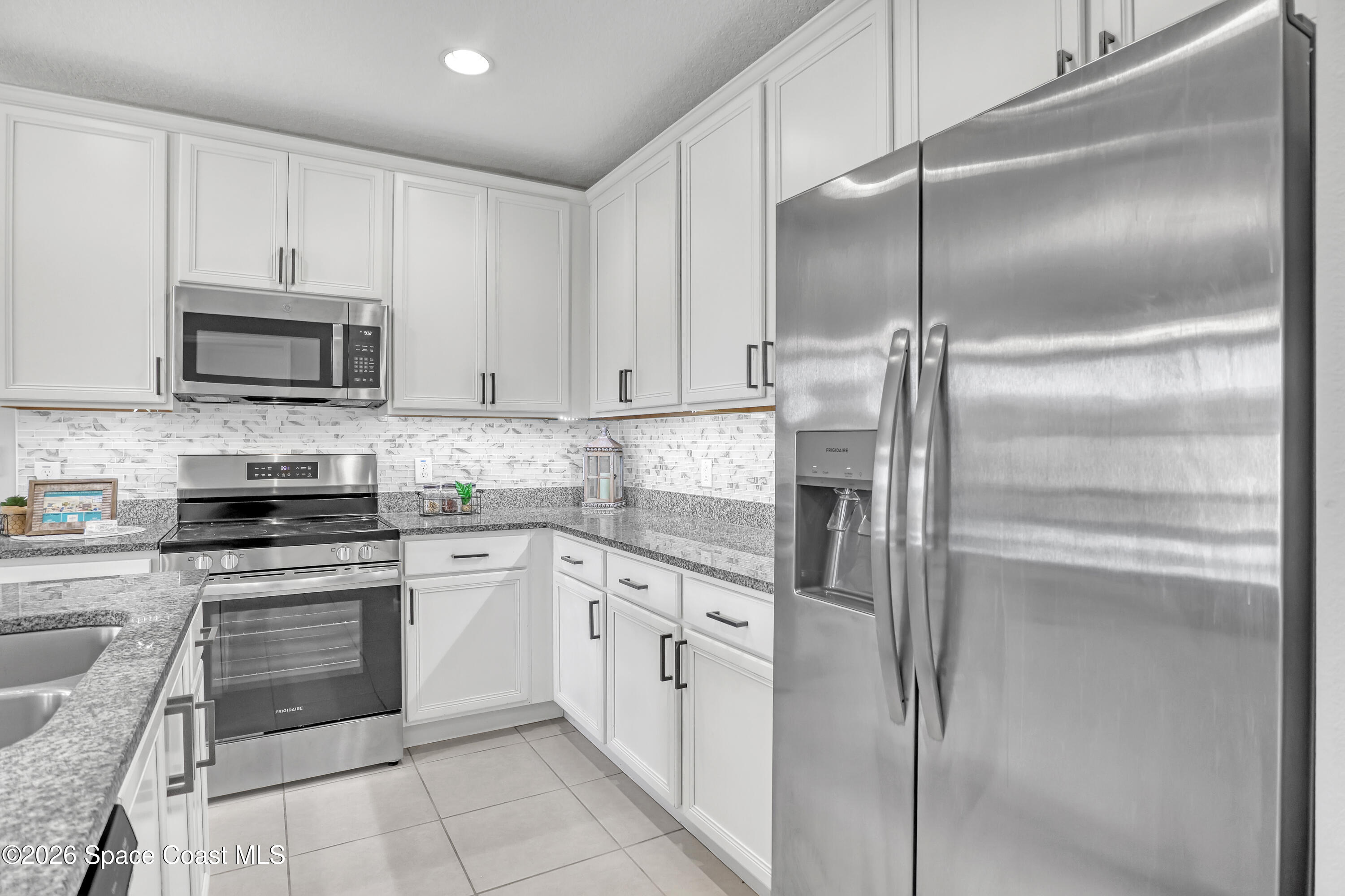 1420 Lara Circle, Unit 102 Rockledge, FL 32955 - Photo 7 of 38 a kitchen with cabinets stainless steel appliances and a counter space