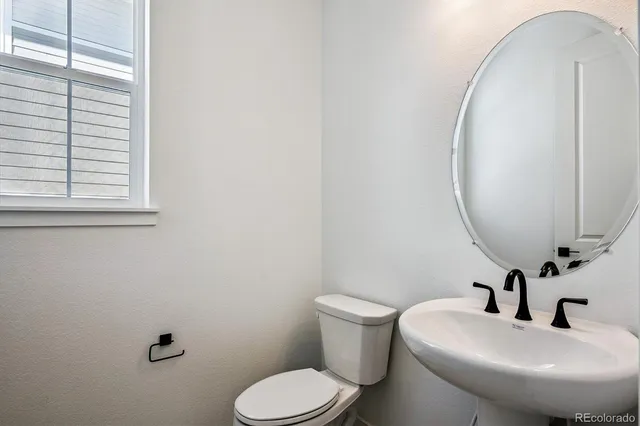 a bathroom with a sink mirror and toilet