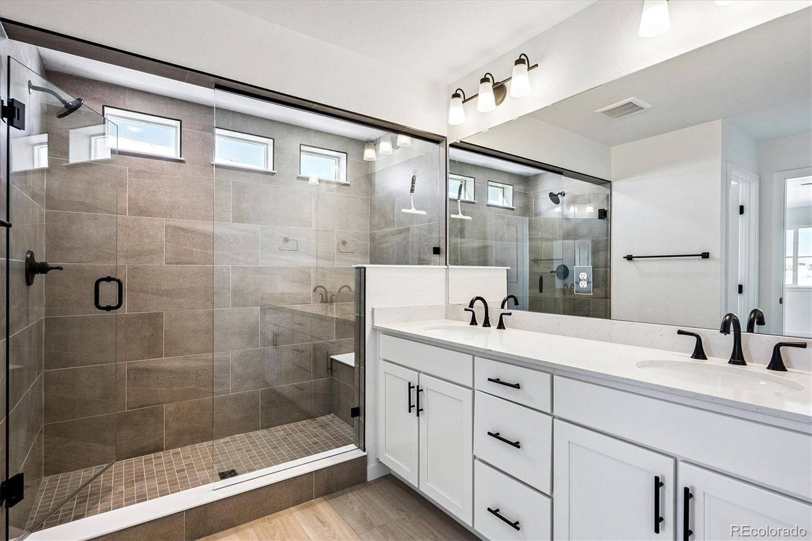 17543 East Virginia Avenue Aurora, CO 80017 - Photo 16 of 26 a bathroom with a double vanity sink mirror and shower
