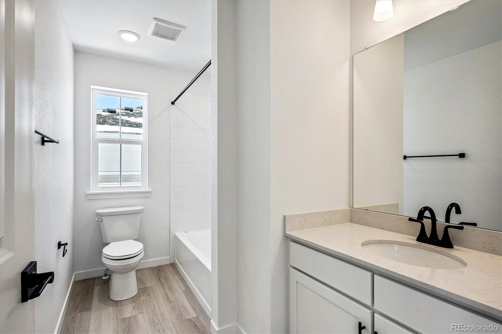 17543 East Virginia Avenue Aurora, CO 80017 - Photo 19 of 26 a bathroom with a toilet a sink and a mirror