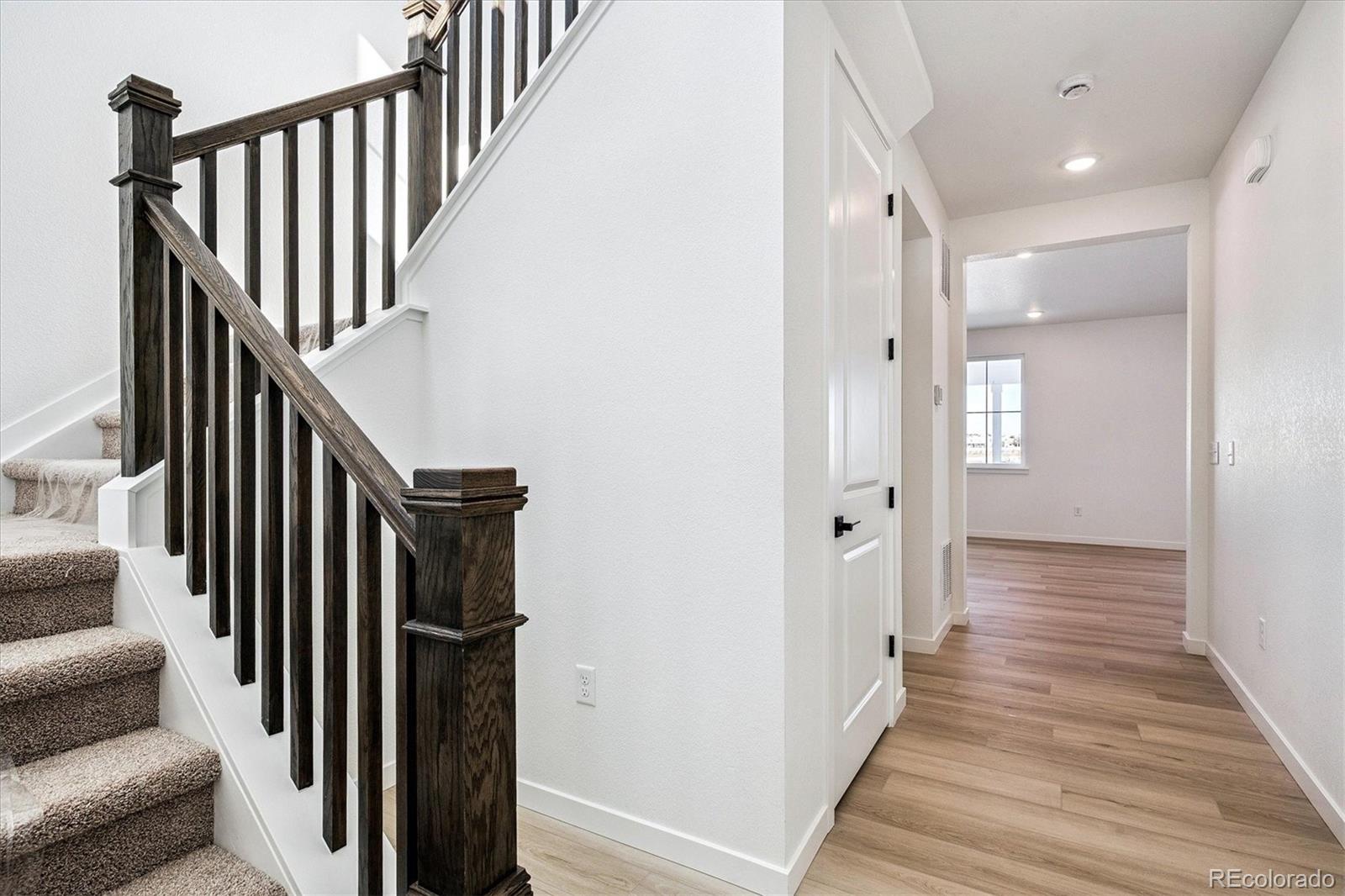 17543 East Virginia Avenue Aurora, CO 80017 - Photo 3 of 26 a view of a hallway with wooden floor and staircase