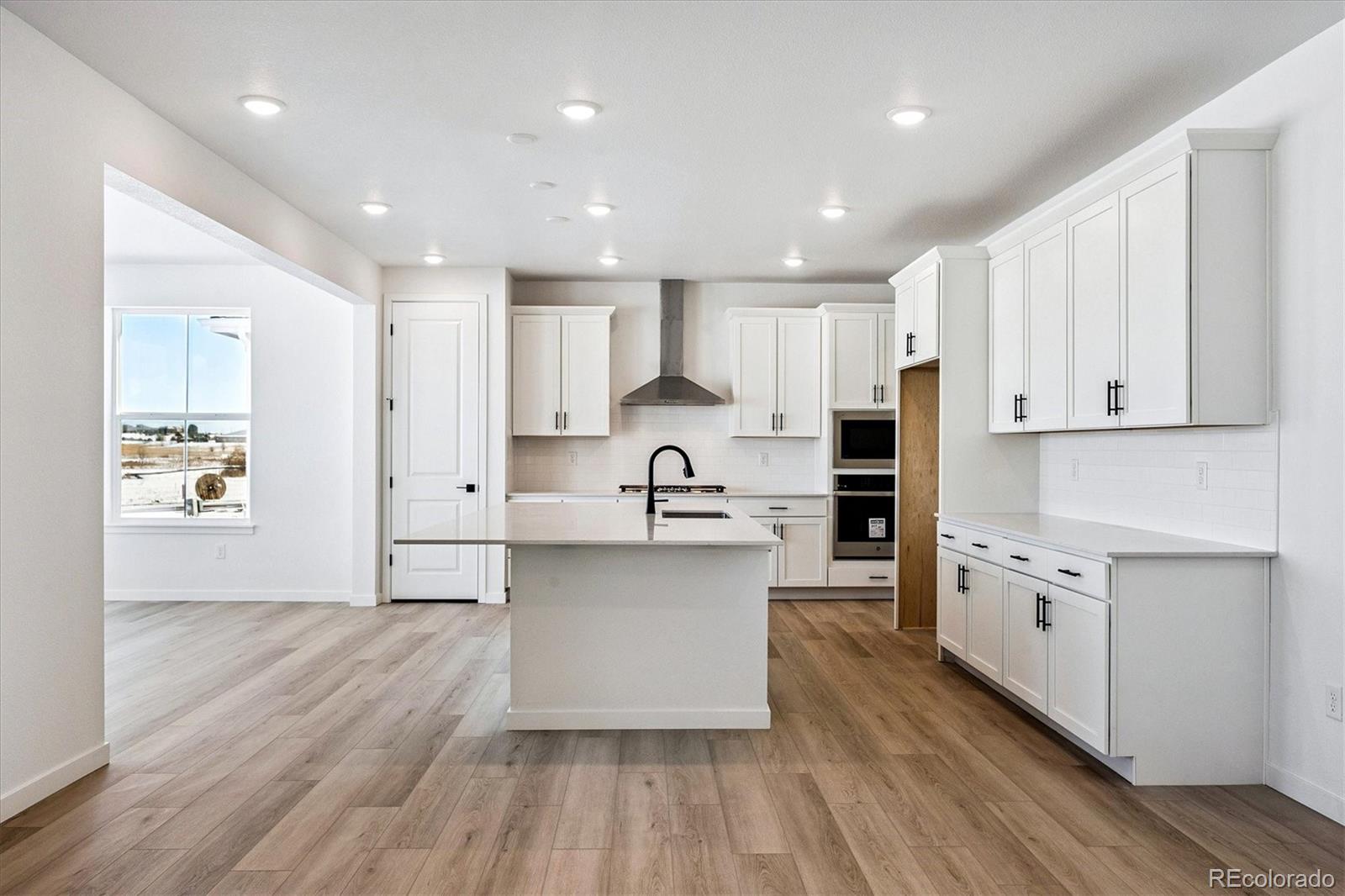 17543 East Virginia Avenue Aurora, CO 80017 - Photo 5 of 26 a large kitchen with stainless steel appliances granite countertop a lot of counter space and wooden floors
