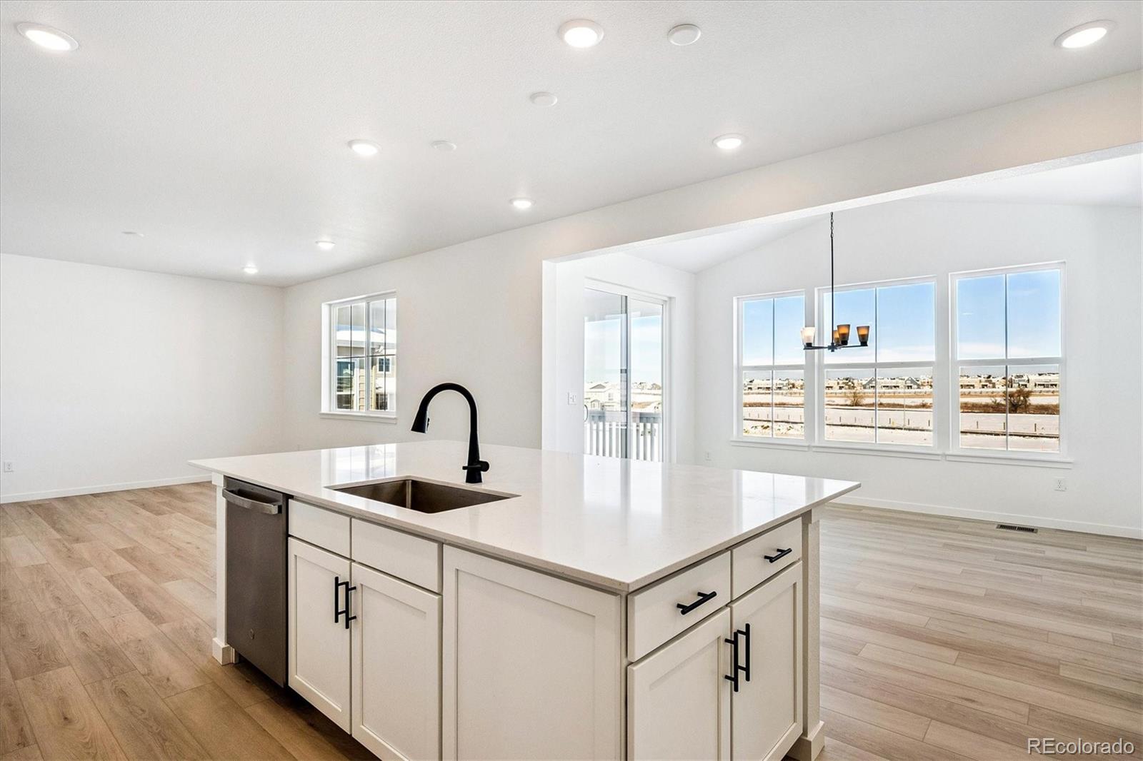 17543 East Virginia Avenue Aurora, CO 80017 - Photo 9 of 26 a kitchen with kitchen island granite countertop a sink cabinets and wooden floor