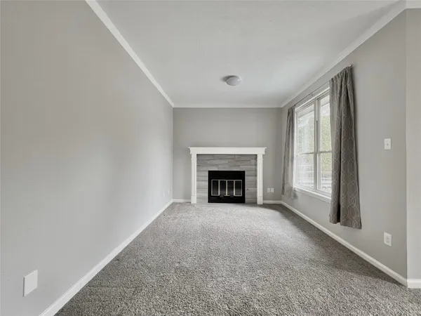 an empty room with windows and fireplace