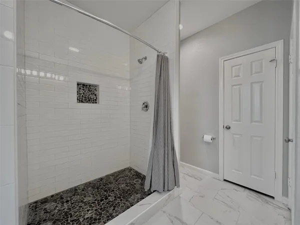 a bathroom with a granite countertop double vanity sink a mirror and a bathtub
