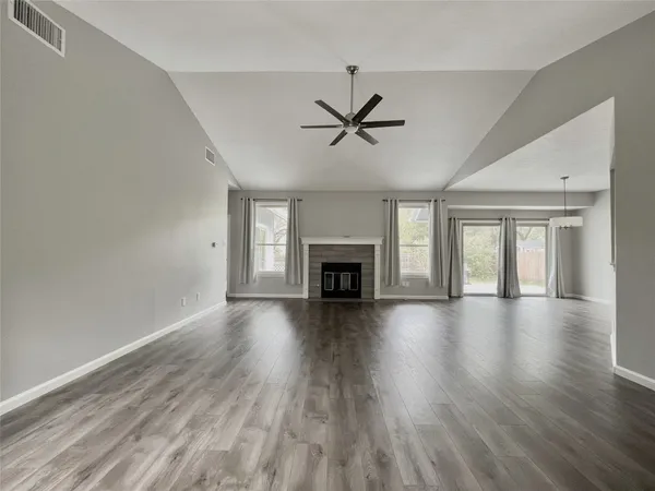 a view of empty room with wooden floor and fireplace