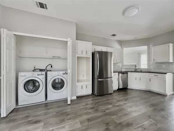 a kitchen with granite countertop white cabinets and a sink